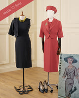 Two vintage-style dress mannequins display coordinated outfits in an indoor room with cream paneled walls and wood flooring. The left mannequin wears a black sleeveless dress with a matching cropped jacket, black heels, and a yellow necklace.